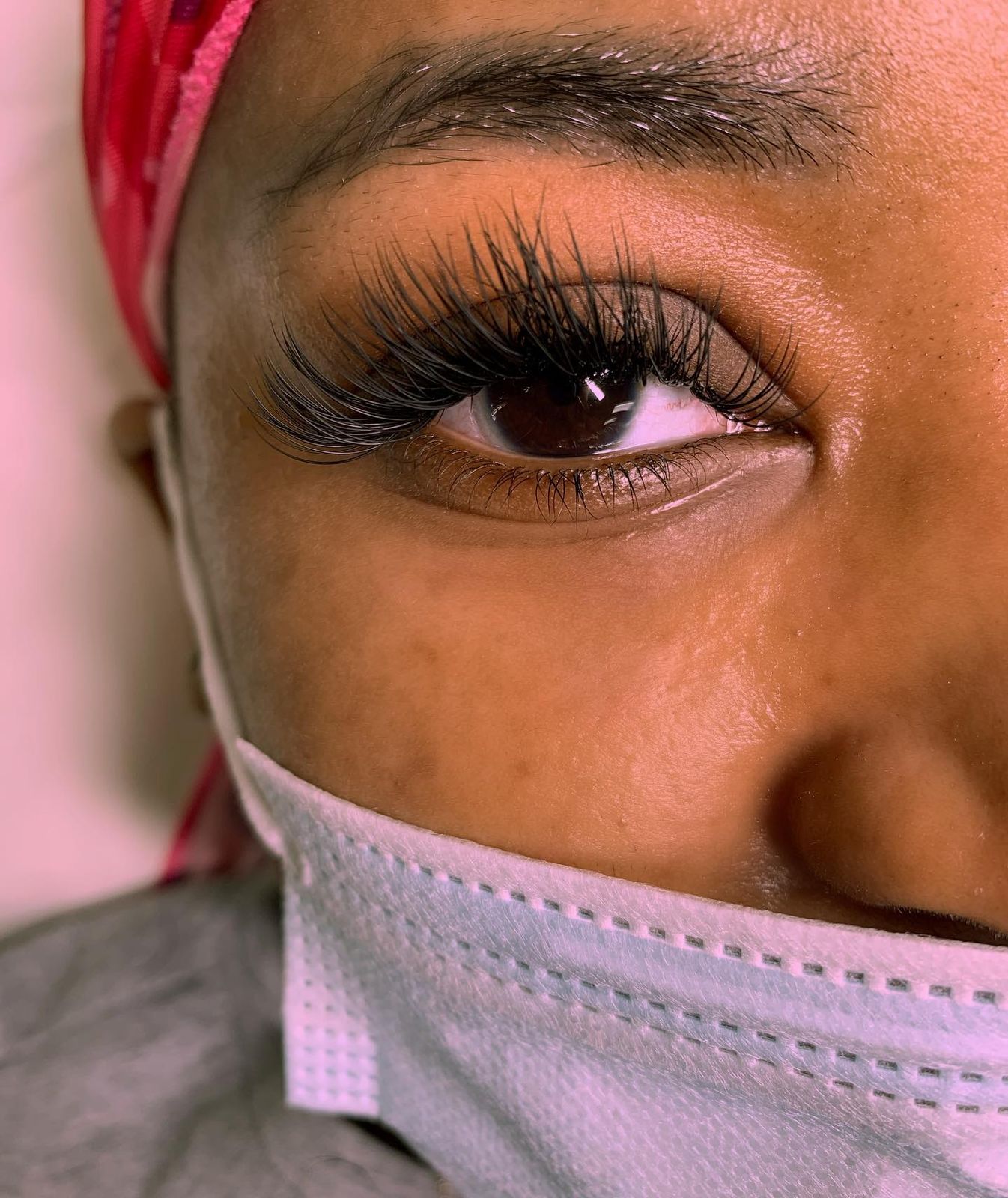 Fluffy set, eye open against a pink backdrop
