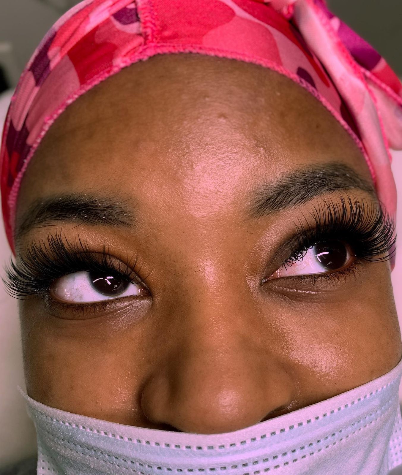 Volume lash set on a client in a pink bonnet